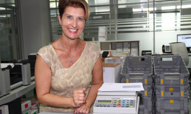 Mitarbeitende mit kurzen Haaren lächelt in die Kamera Mitarbeitende mit kurzen Haaren lächelt in die Kamera